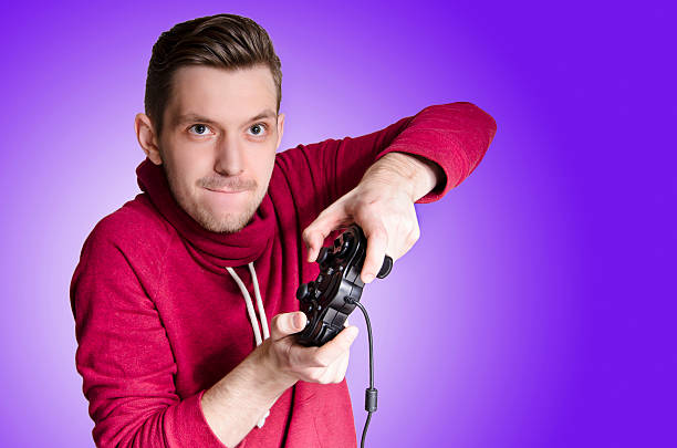 Young man playing video game Young adult playing video games very intense funny,purple gradient background muster station stock pictures, royalty-free photos & images