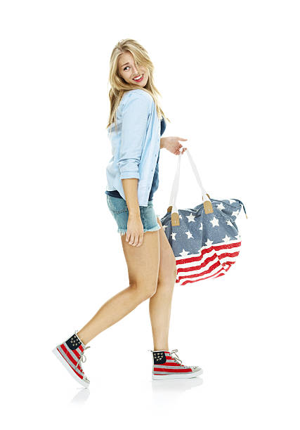 istock Smiling woman holding purse and walking 529137484