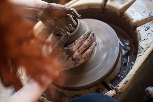 Hands working on pottery wheel Human hands working on pottery wheel, close up pottery making stock pictures, royalty-free photos & images