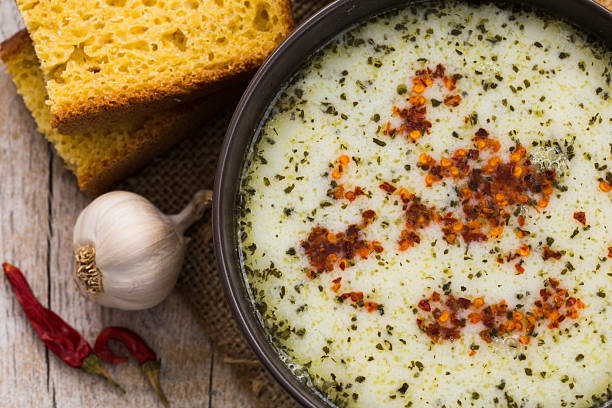 Bowl of soup with bread and garlic Bowl of soup with bread and garlic on the wooden table plateau stock pictures, royalty-free photos & images