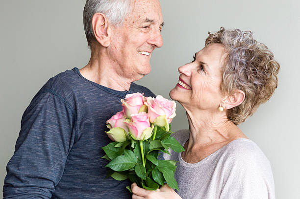 istock Older couple looking at each other with flowers 529140944