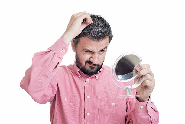 istock Man looking in the mirror at the first grey hair 529141814