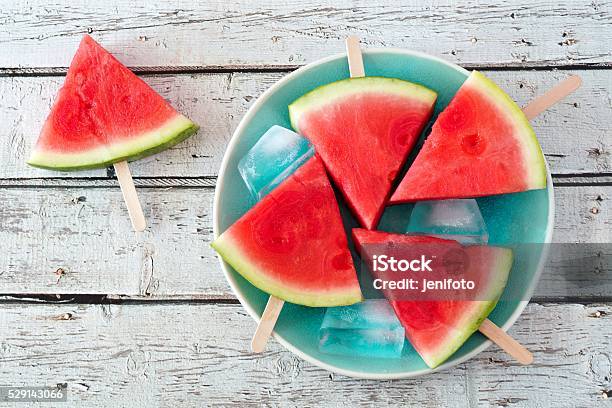 Watermelon Slice Popsicles On Blue Plate Over Rustic Wood Stock Photo - Download Image Now