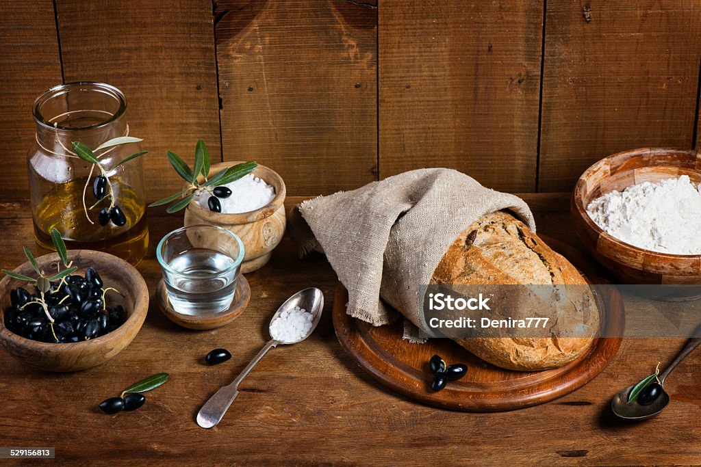 Ingredients for making bread with olives Cooking bread with olives ( wholemeal,  water, olives, olive oil) on a wooden table 7-Grain Bread Stock Photo