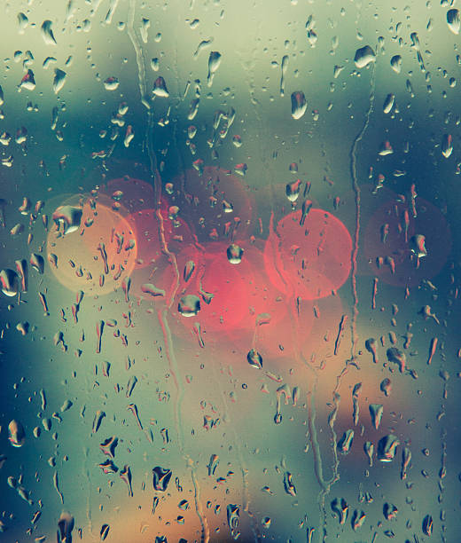 istock rain drops on the window with traffic bokeh light 529159017