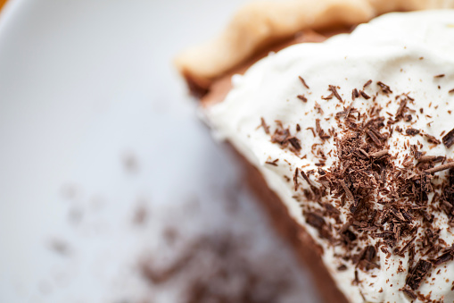 A generous piece of French silk pie served fresh with homemade whip cream and shaved chocolate.