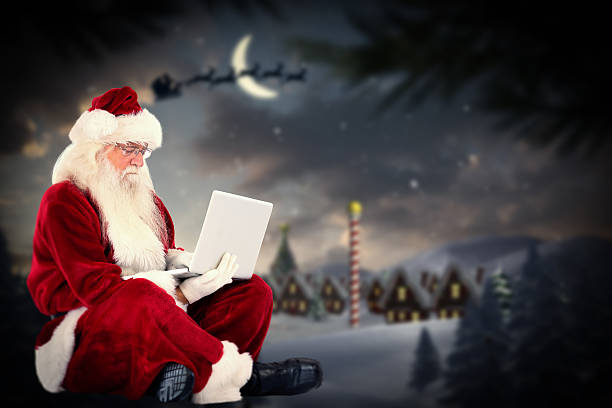 istock Composite image of santa sits and uses a laptop 529174401