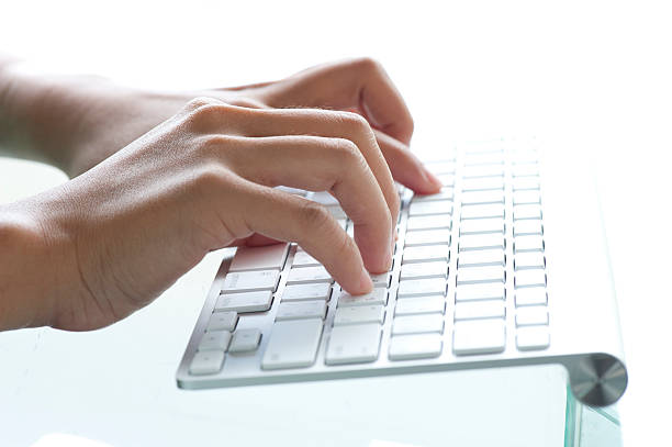 Female office worker typing on the keyboard stock photo