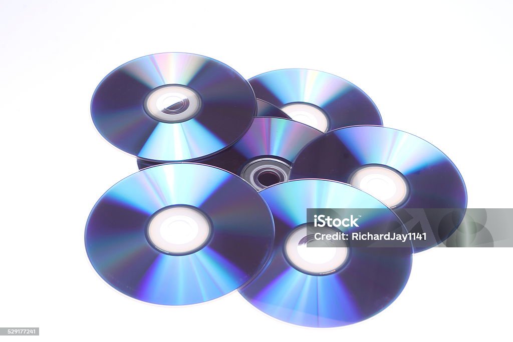 CD and DVD Light playing on a row of CDs and DVDs creating rainbows as the light refracts upon the surface Compact Disc Stock Photo