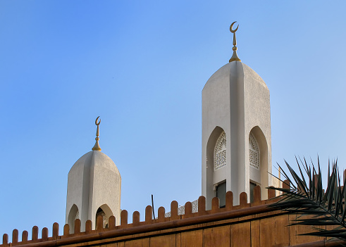 Two minarets of a small mosque in Dubai - Deira. Simple shape, contrasting with an early evening sky.