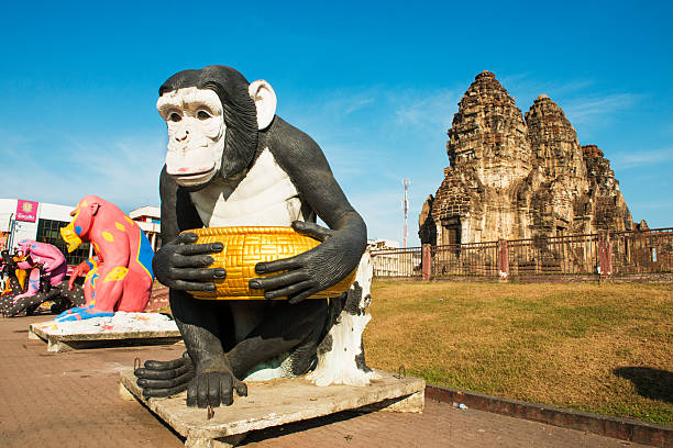 Lopburi, Thailand - December 9, 2014: In front of the temple ruins known as the Monkey Temple, giant monkey sculptures that commemorate the primate inhabitants line the sidewalk.