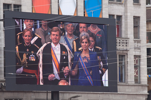 Amsterdam,The netherlands - april 30-2013: King alexander and queen maxima during the inauguration on a great tv screen on dam square. 