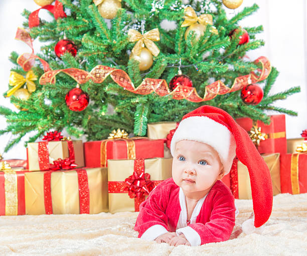istock child in christmas hat against decorated fir tree 529192245