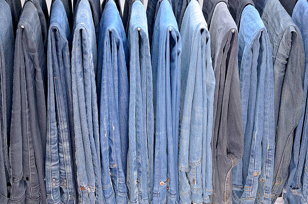 istock Many colored jeans hanging on hangers 529193583
