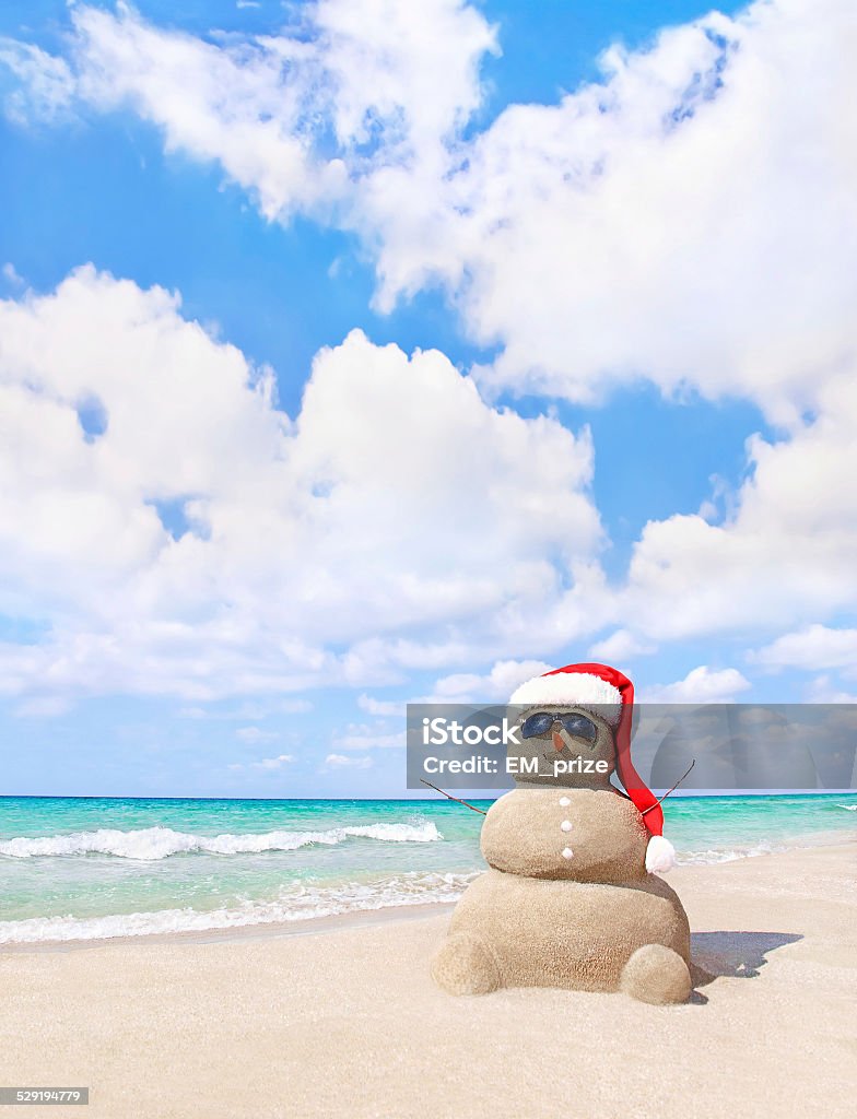 Navidad muñeco de nieve en santa sombrero en la playa de arena - Foto de stock de Playa libre de derechos
