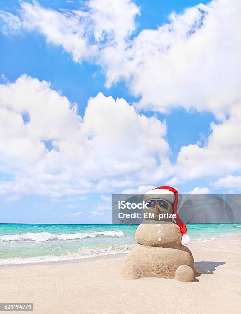Christmas Snowman In Santa Hat At Sandy Beach Stock Photo - Download Image Now - Beach, Christmas, Sand