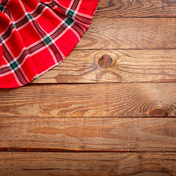 istock Wood texture, wooden table with red tablecloth tartan top view. 529206901