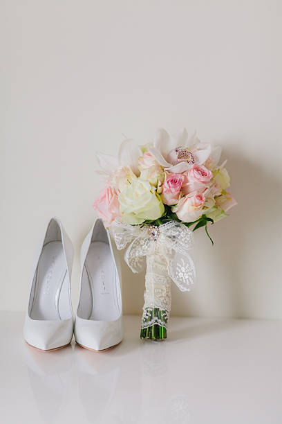 istock wedding bouquet  with orchids and roses and weddind bride's shoe 529208487