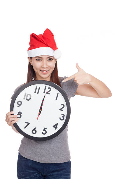 istock Asian girl with red santa hat point to a clock 529209795