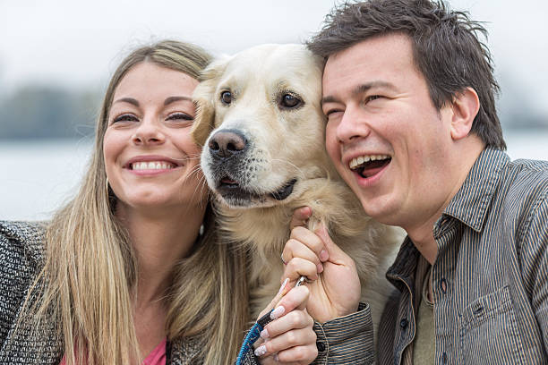 istock Smiling young man and woman hugging a dog 529224249