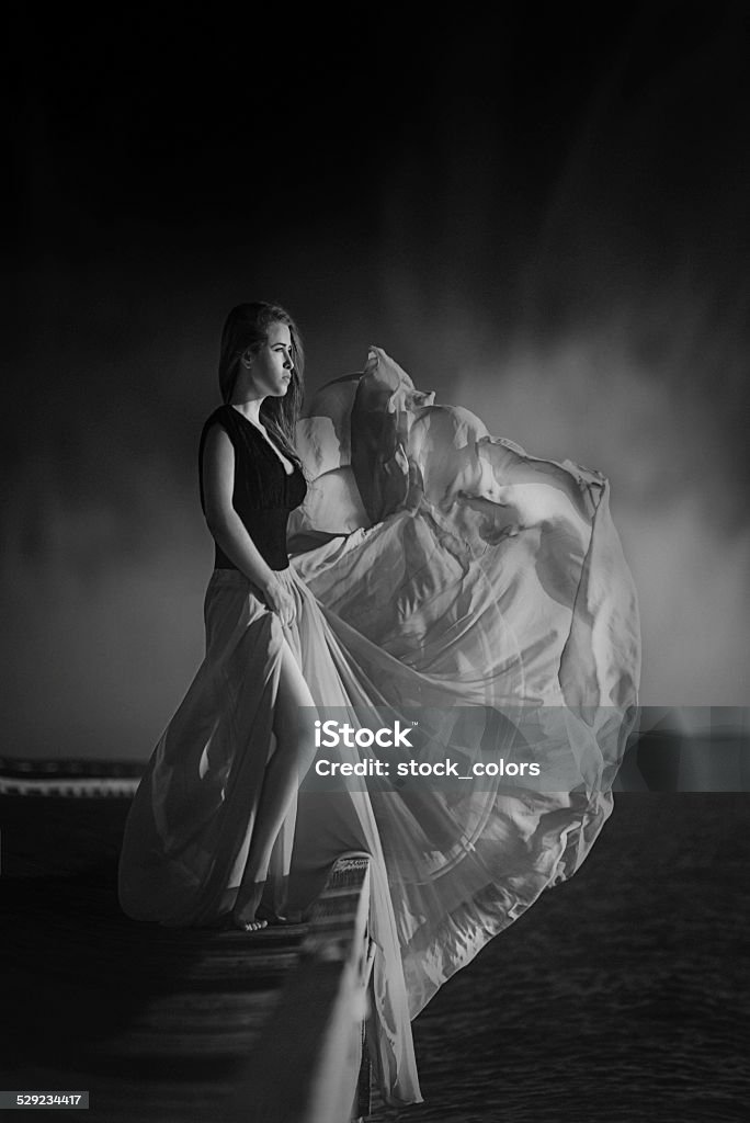 mystery and wind woman on bridge with windy dress posing. 25-29 Years Stock Photo