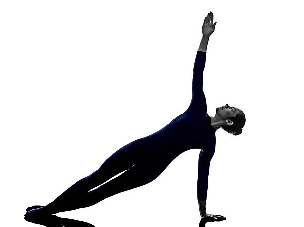 istock woman exercising Vasisthasana side plank pose yoga silhouette 529235155