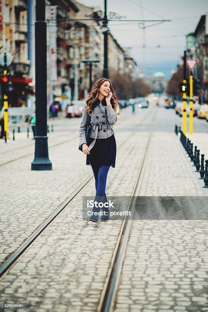 Young woman with smart phone walking on the street Young woman talking on the phone and smiling 20-29 Years Stock Photo