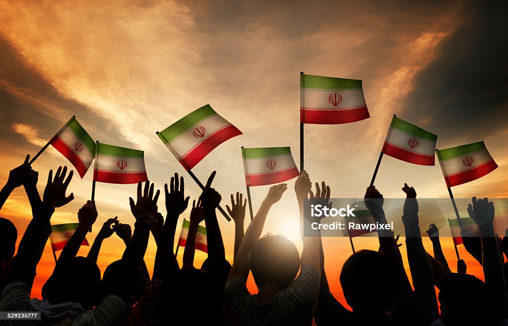 Silhouettes of People Waving the Flag of Iran ***NOTE TO INSPECTOR: All models in this image have signed model releases. Some models have been duplicated more than once.*** All Middle Eastern Flags Stock Photo