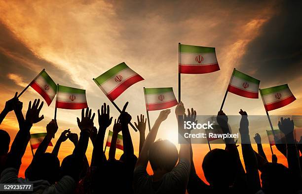 Silhouettes Of People Waving The Flag Of Iran Stock Photo - Download Image Now - All Middle Eastern Flags, Back Lit, Celebration