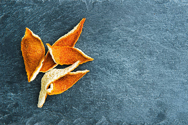Closeup on dried orange peels on stone substrate