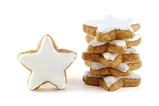 Christmas cookies, stack of cinnamon stars, a single one standing, in germany called zimtsterne, close up isolatet on white background