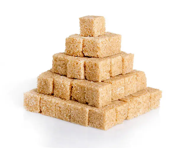 Pyramid of cane sugar cubes isolated on white background