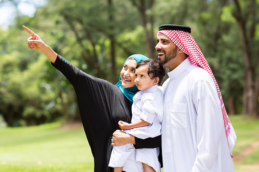 cute arabian family looking and pointing in the forest