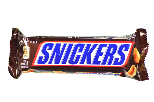 Kwidzyn, Poland – February 27, 2014: Snickers chocolate bar isolated on white background. Snickers bars are produced by Mars Incorporated. Snickers was created by Franklin Clarence Mars in 1930