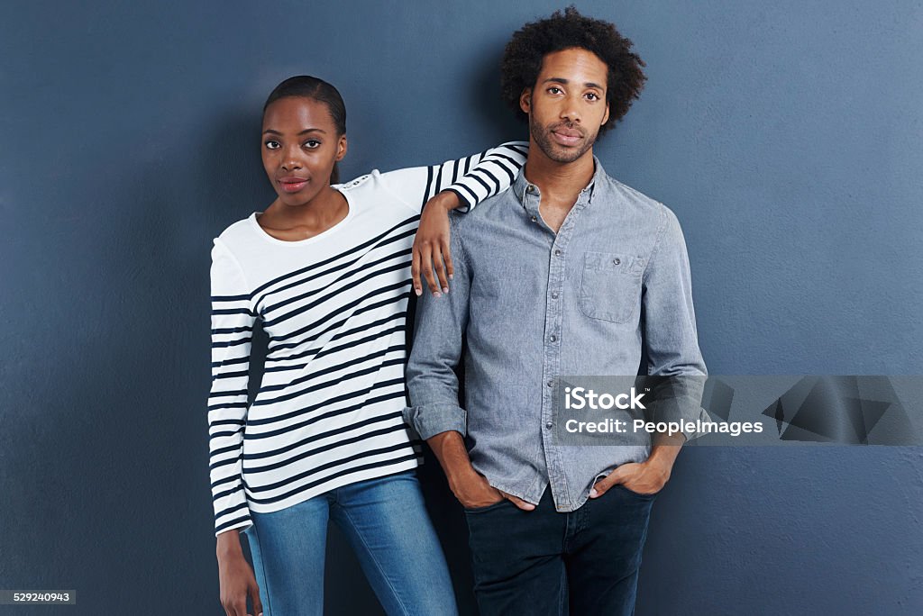 Their relationship is getting serious Portrait of a beautiful young couple on a gray background Serious Stock Photo