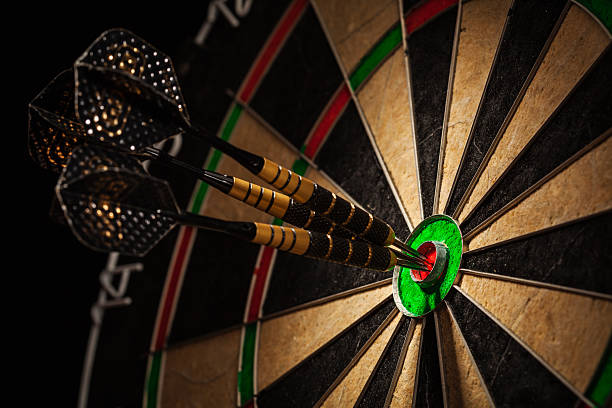 Three darts in bull's eye close up Success hitting target aim goal achievement concept background - three darts in bull's eye close up dartboard stock pictures, royalty-free photos & images