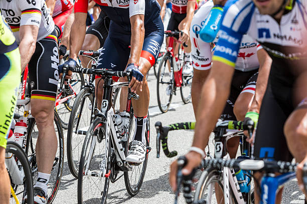 Inside the Peloton Col du Lautaret, France - July 19, 2014: Image of the legs of cyclists inside the peloton, pedalling during the stage 14 of Le Tour de France 2014 on Col du Lautaret in Hautes Alpes. tour de france stock pictures, royalty-free photos & images