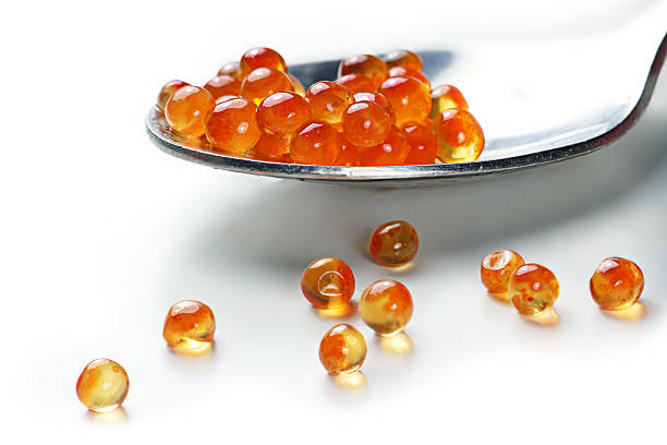 istock spoon with red caviar, close up on white 529250845