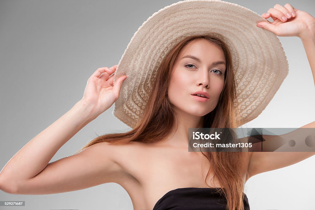 Beautiful girl with hat posing in studio Close-up portrait of beautiful girl with hat posing in studio isolated on gray background Activity Stock Photo