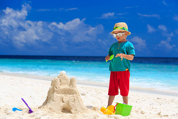 istock little boy building sand castle on beach 529271907