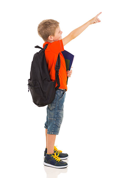 primary schoolboy pointing at empty copyspace primary schoolboy pointing at empty copyspace isolated on white elementary student pointing stock pictures, royalty-free photos & images