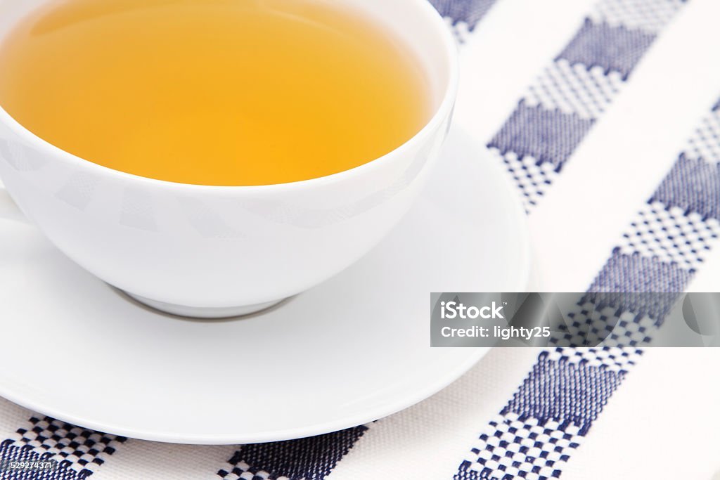 Cup of chamomile tea on checkered tablecloth Cup of chamomile tea on checkered tablecloth. Closeup view. Chamomile Stock Photo