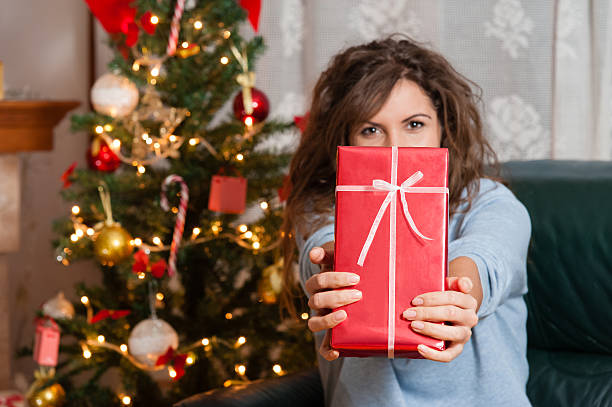 istock Young woman with christmas present box 529277051