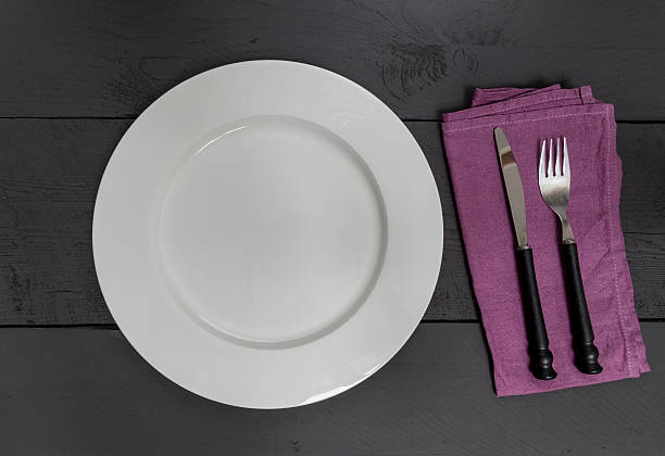 istock Cutlery and plate on black wooden background 529277499