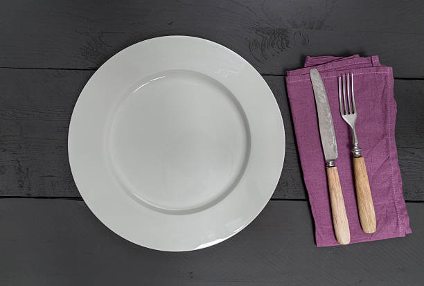 istock Cutlery and plate on black wooden background 529277527