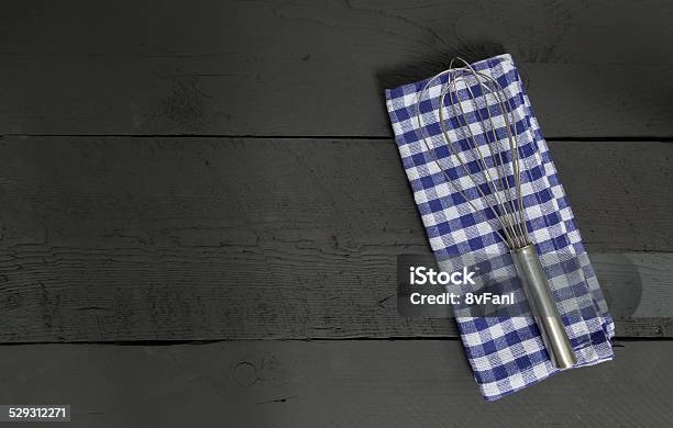 Whisk And Tea Towel On Black Wooden Background Stock Photo - Download Image Now - Anthracite Coal, Commercial Kitchen, Cooking