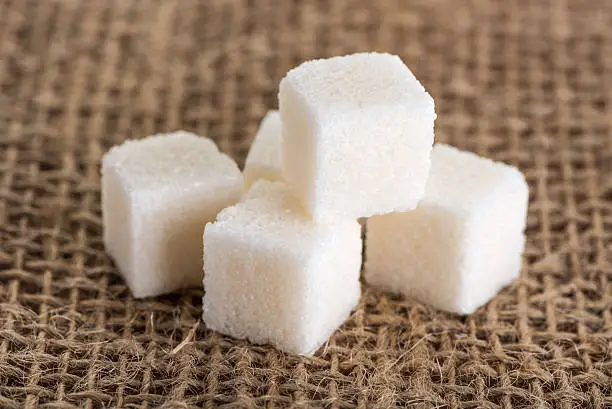 cubes white and sugar on a background of jute bags