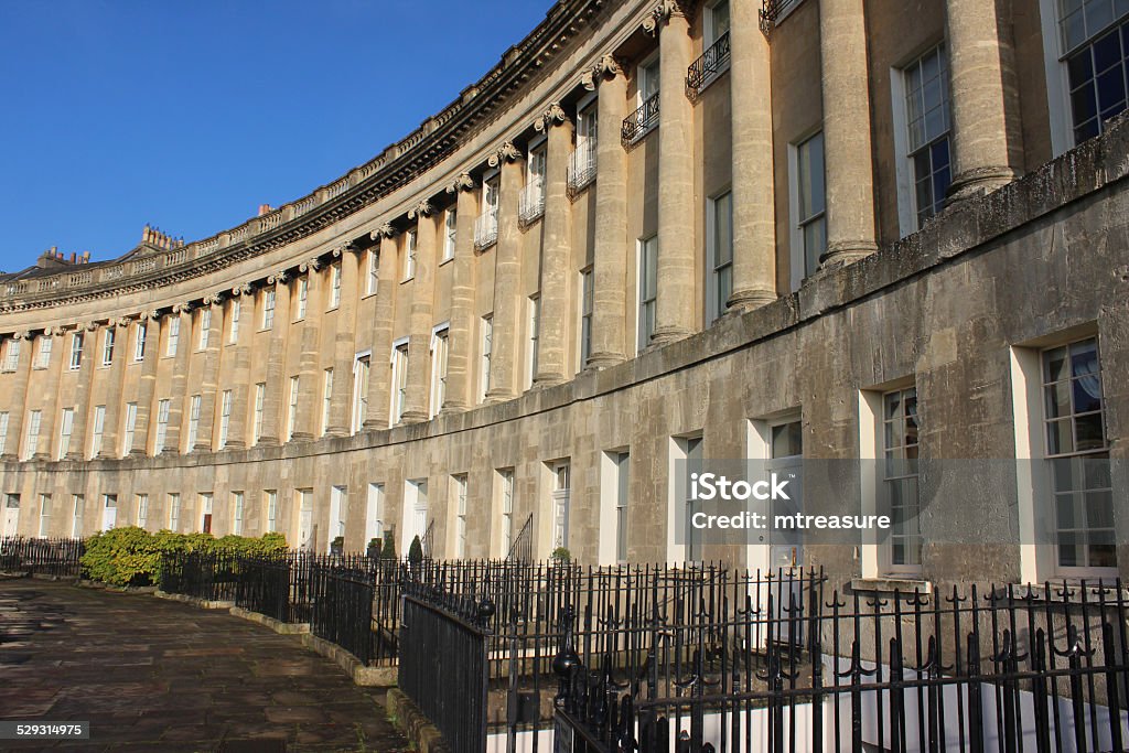 Historic terraced town-houses / Georgian architecture / Bath stone, Royal Crescent, England Photo showing a crescent of terraced town houses / historic Georgian buildings and their ornate architecture, made from sand-stone coloured Bath stone.  The houses are known as The Royal Crescent (often confused with The Circus) and form a semi-circle / crescent shape, being located in the centre of Bath, Somerset, England, UK. Apartment Stock Photo