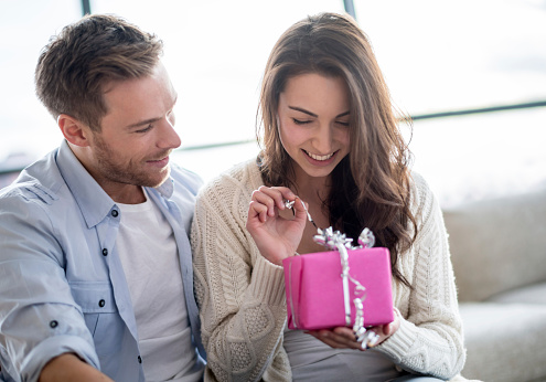 Woman opening a present from her boyfriend