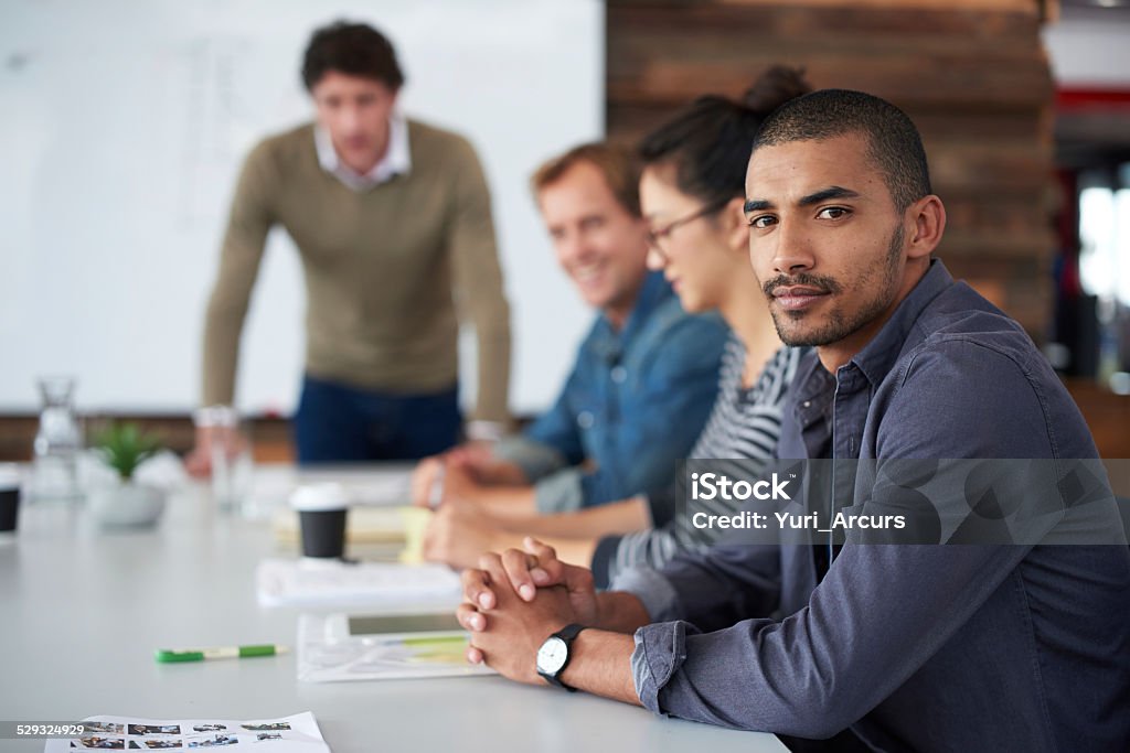 Success is serious business Portrait of a group of coworkers sitting at a conference table Adult Stock Photo